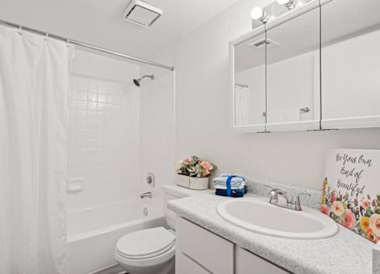Casa Bella  A white bathroom with a toilet, sink, and shower.