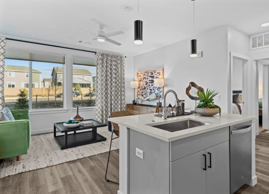 an open living room and kitchen with a large window and a sink