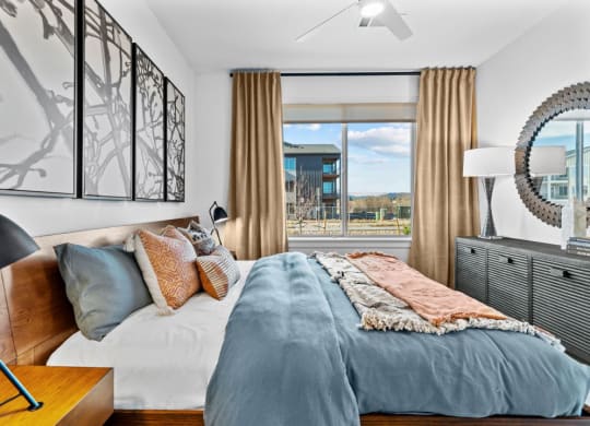 a bedroom with a bed and a large window