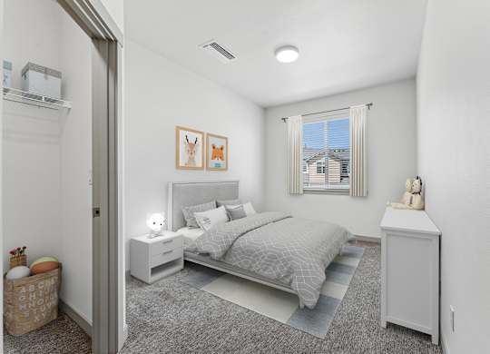 A bedroom with a bed, nightstand, and a window with a view of a building outside.