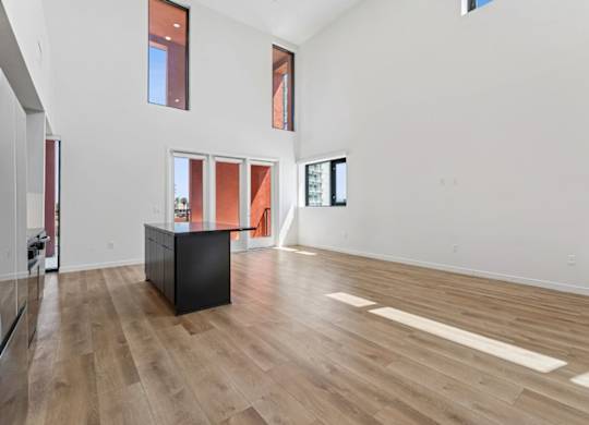 A room with a black cabinet and wooden flooring.