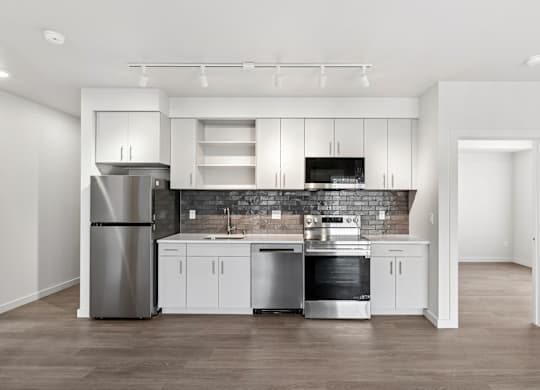 A modern kitchen with stainless steel appliances and white cabinetry.