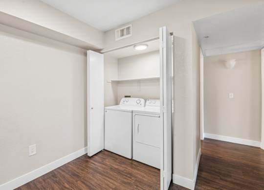 A white washer and dryer are in a small laundry room.
