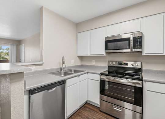 A kitchen with a stainless steel dishwasher and oven.