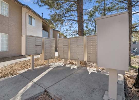 A row of mailboxes in front of apartment buildings.