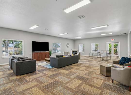 A spacious waiting room with a variety of seating options and a flat screen TV.