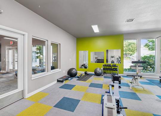 A gym with a variety of equipment including a rowing machine.