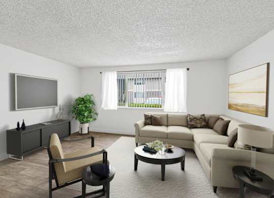 A living room with a grey sofa, a brown armchair, a coffee table, and a flat screen TV mounted on the wall.