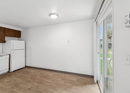 A kitchen with white appliances and wooden cabinets.