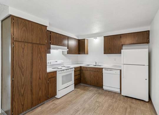 A kitchen with white appliances and wooden cabinets.