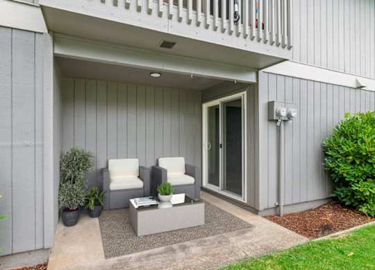 A patio area with two chairs and a table.