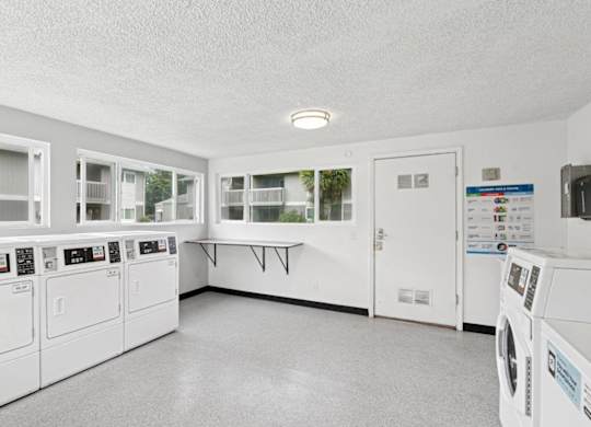 A laundry room with washers and dryers.
