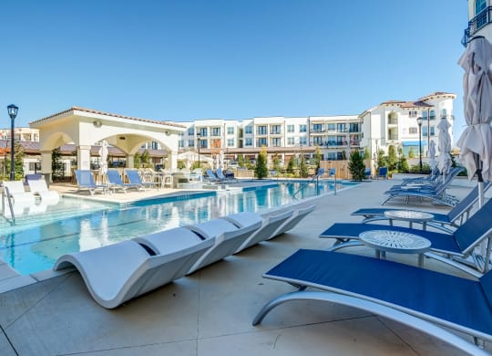 The Dylan  resort style pool with lounge chairs and umbrellas