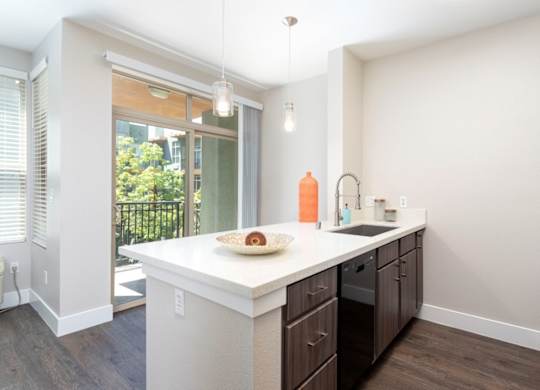A kitchen with a white countertop and wooden cabinets.