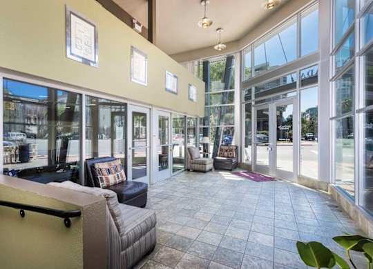A spacious waiting area with comfortable seating and large windows.