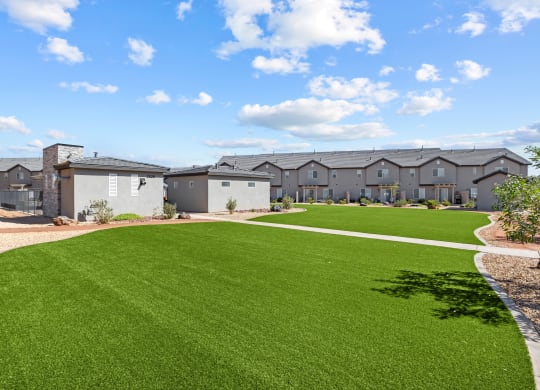 a green lawn in front of a row of apartment buildings