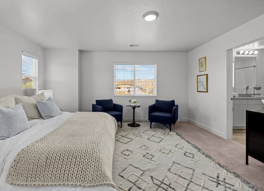 a bedroom with a large bed and two chairs