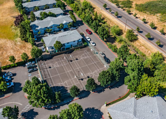 an aerial view of a tennis court in a residential neighborhood