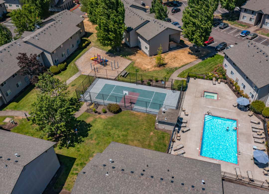 an aerial view of a house with a pool and tennis court