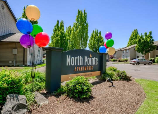 a sign that says north point apartments with balloons in front of it