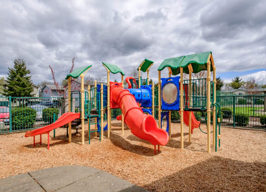 a playground with a red slide and red and blue slides