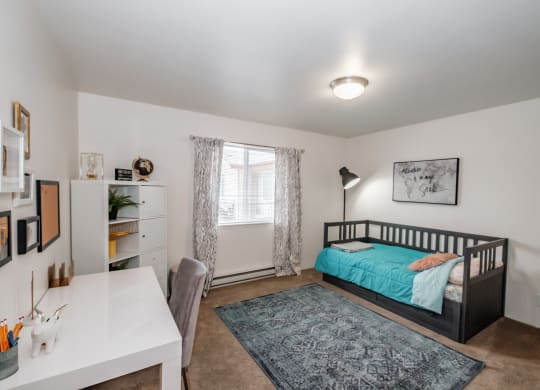 a bedroom with a bed and a desk with a chair