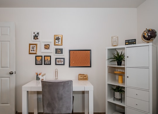 a home office with a white desk and a grey chair