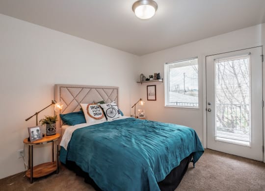 a bedroom with a bed and two windows