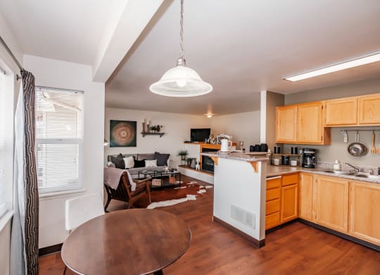 a kitchen and living room with wood floors and white appliances
