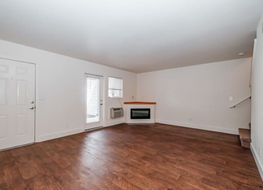 a living room with hardwood floors and white walls