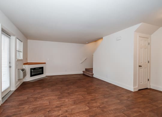 a living room with white walls and a wooden floor