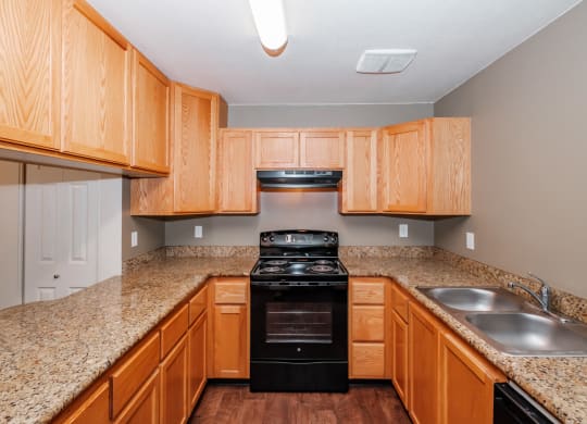 a kitchen with wood cabinets and granite countertops
