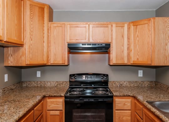 a kitchen with wooden cabinets and granite countertops
