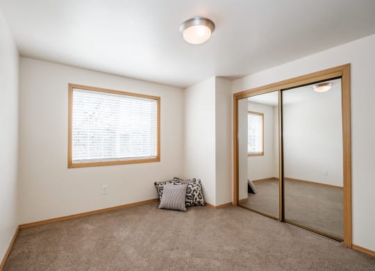 a bedroom with carpeted floors and a large mirror