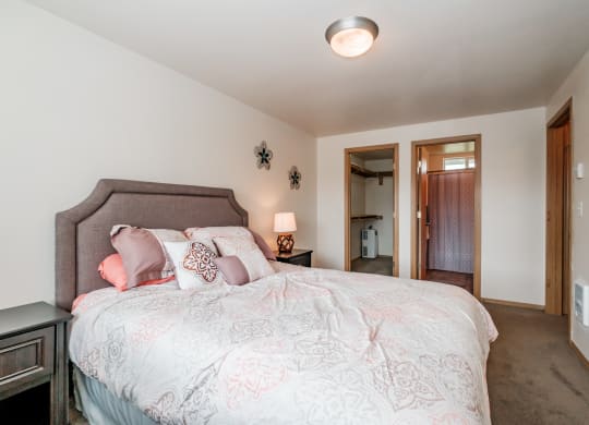 a bedroom with a large bed and a door to a bathroom