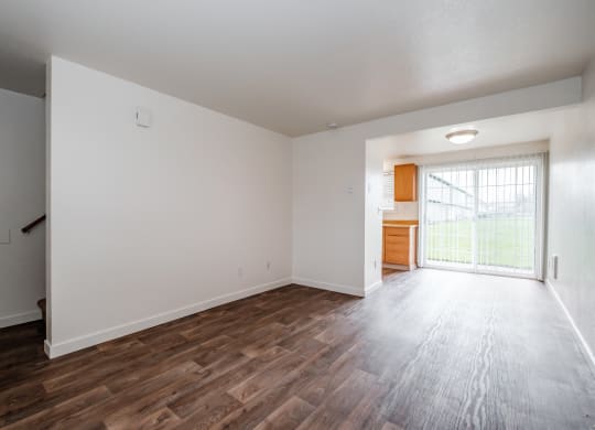 a bedroom with hardwood floors and white walls