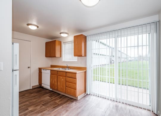 a kitchen with wood flooring and a large sliding glass door