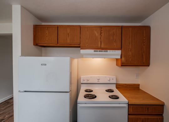 a kitchen with white appliances and wooden cabinets