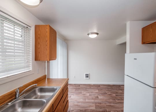 a kitchen with wood cabinets and a stainless steel sink