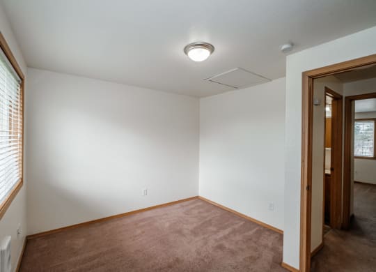 a bedroom with white walls and a carpeted floor