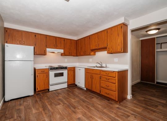 a kitchen with white appliances and wooden cabinets
