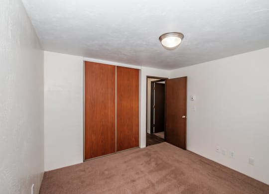 a bedroom with white walls and a carpeted floor