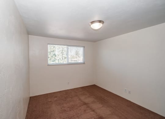 a small room with white walls and a small window