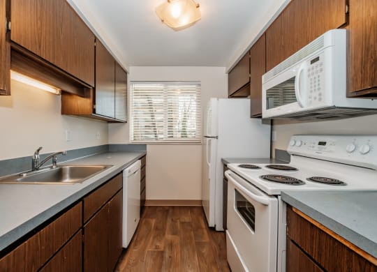 a kitchen with white appliances and wooden cabinets