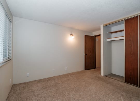 a bedroom with a closet and a window