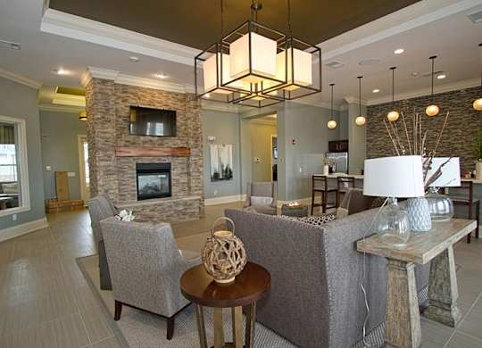 A living room with a grey couch, a stone fireplace, and a wooden coffee table.