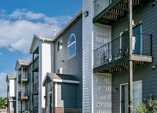 A row of modern townhouses with balconies and garages.