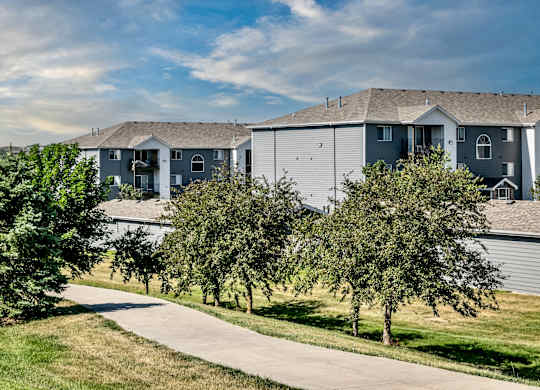 A row of houses with trees in front.