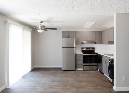a kitchen with stainless steel appliances and a ceiling fan