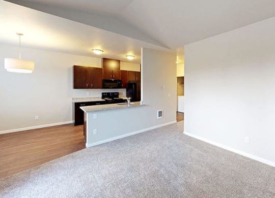 an empty room with a kitchen and a living room